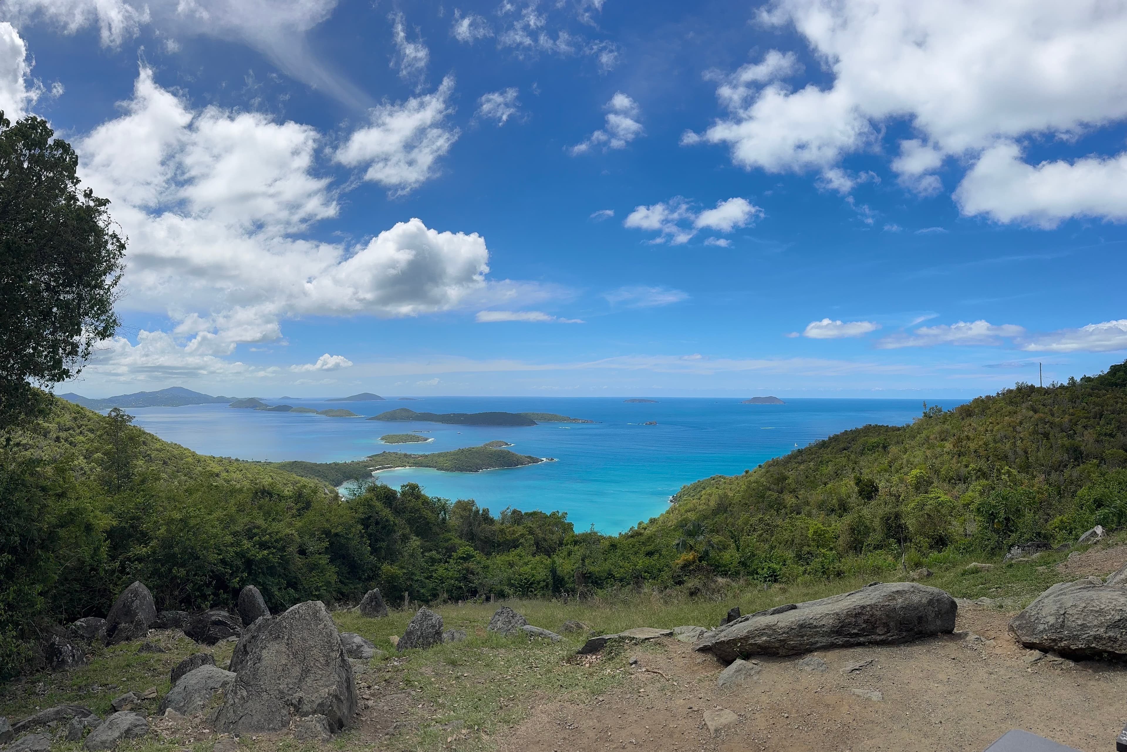 BVI overlook — green hills meet a turquoise bay, slow pastoral mood
